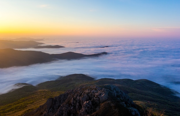 Mountain landscape at sunset with low clouds