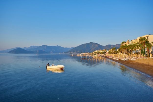 Mountain and lonely motor boat reflected sunrise in a calm sea Marmaris