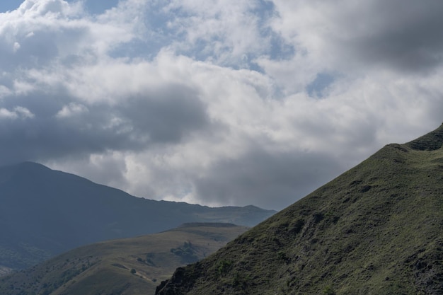 Mountain peaks against cloudy sky Peaks of magnificent rocks located against bright cloudy sky