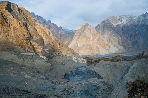 Mountain peaks in Karakoram range near moraine and glacial lake in Passu, Pakistan.