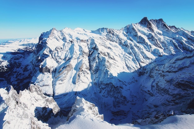 冬のスイスアルプスのヘリコプタービューで山頂の尾根