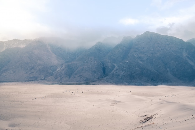 Photo mountain range in the fog. katpana cold desert at sarfaranga, skardu. gilgit baltistan, pakistan.