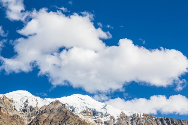 Mountain range next to Nanga Parbat mountain peak with clouds over them from Fairy Meadow. Gilgit, P