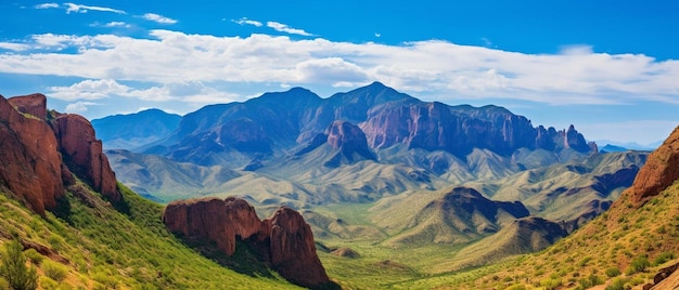 a mountain range with a blue sky and clouds in the background