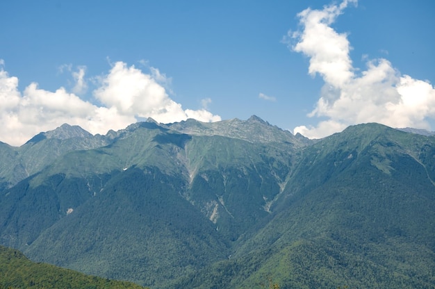 Photo a mountain range with a blue sky and clouds