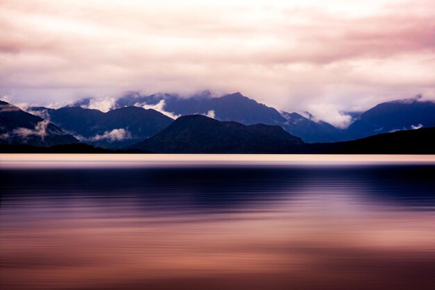 a mountain range with a lake and mountains in the background