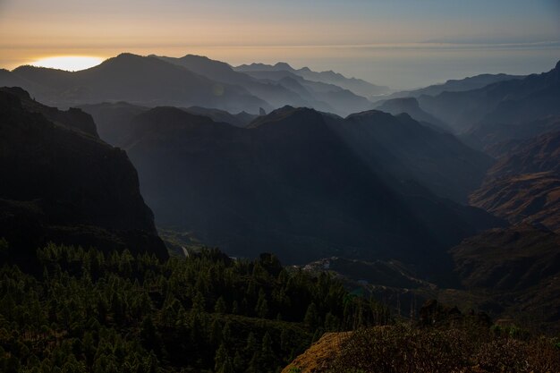 Mountain range with visible silhouettes through the colorful fog