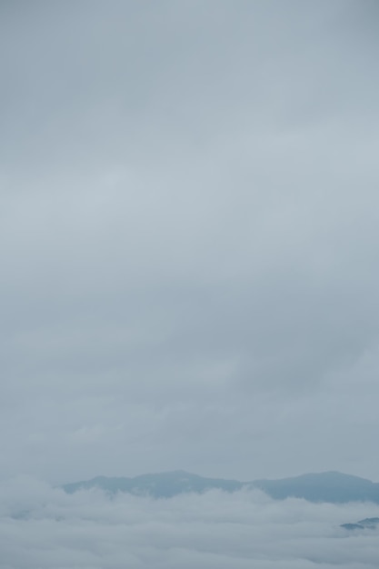 Photo mountain range with visible silhouettes through the morning blue fog