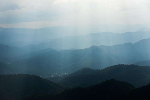 朝のカラフルな霧を通して目に見えるシルエットと山脈