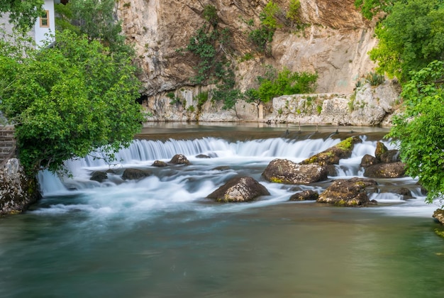 The mountain river formed a small waterfall among the stony rapids