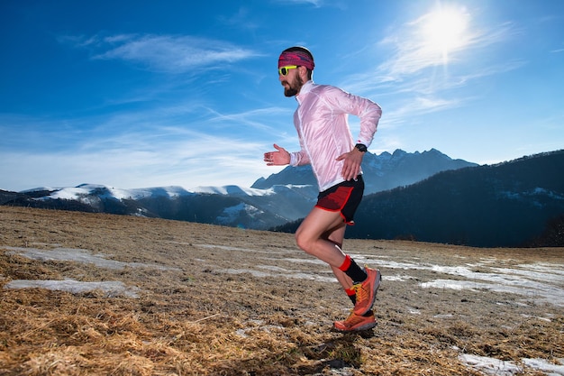 Mountain runner in action uphill on slippery ground