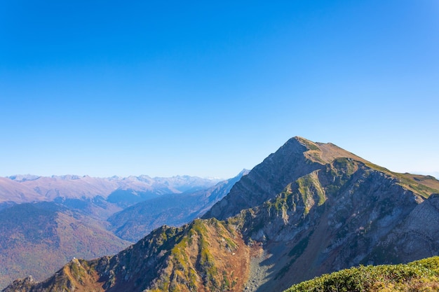 晴天の山の風景の遠くのパノラマの山の頂上