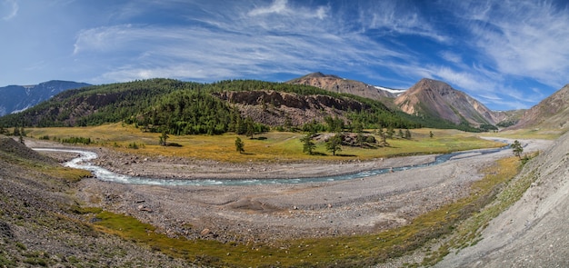 Mountain valley with river, dry slopes and forest