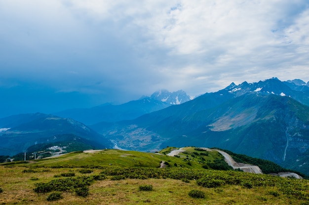 Mountain valley with snow peaks and clouds in Tetnuldi, Mestia, Georgia