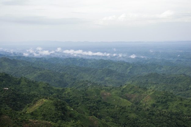 Mountain view with clouds and the horizon at Bandarban Bangladesh Green hill forest with village landscape photography Amazing hill view with thick clouds Country tourist spot with the rural area