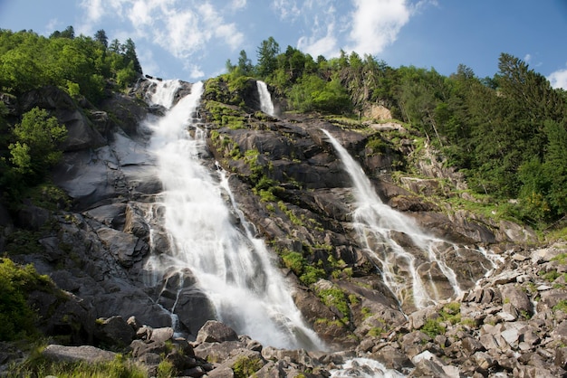 A mountain waterfall on the clear sun day in summer