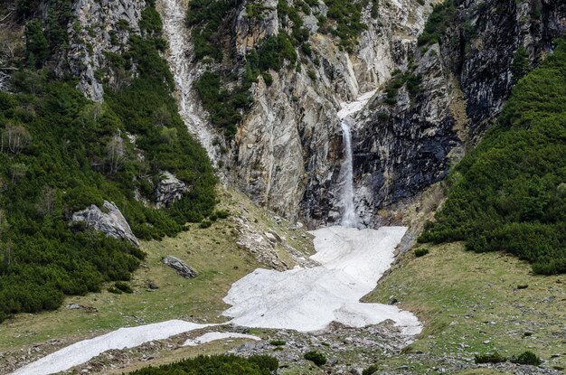 Mountain waterfall and snow