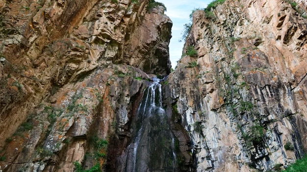 Mountain waterfall with steep cliffs