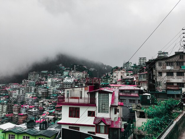 Mountain and white clouds in front of houses in Himachal Pradesh