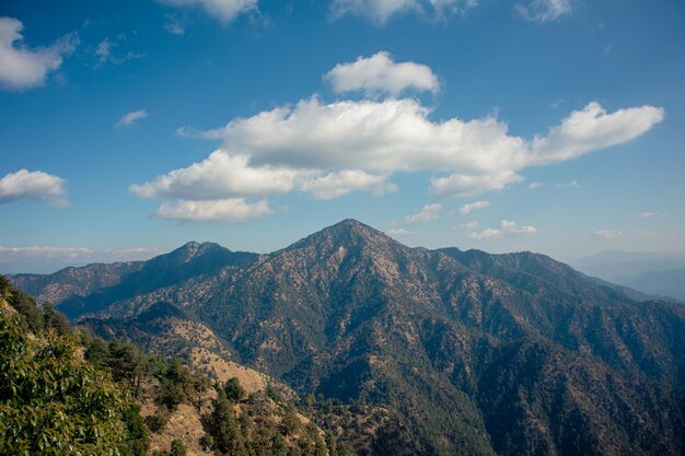 Photo a mountain with a blue sky and clouds in the background