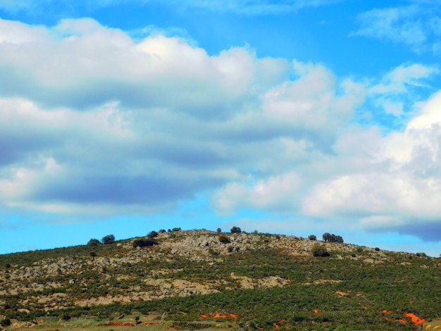 A mountain with a blue sky and clouds