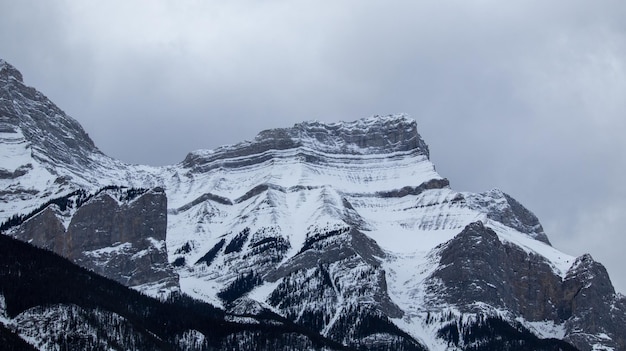 Photo a mountain with a mountain in the background and a cloudy sky