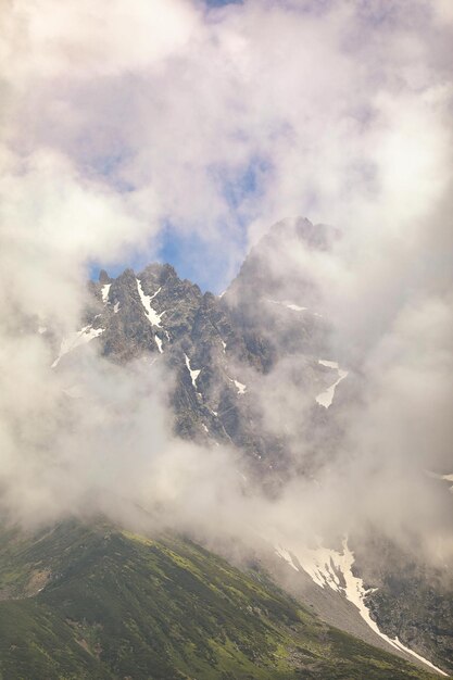 Photo a mountain with the name  the  on it  is surrounded by clouds