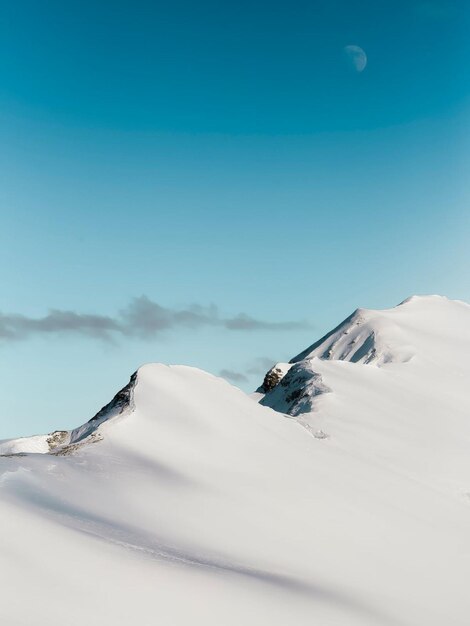 A mountain with snow on it and a blue sky in the background.