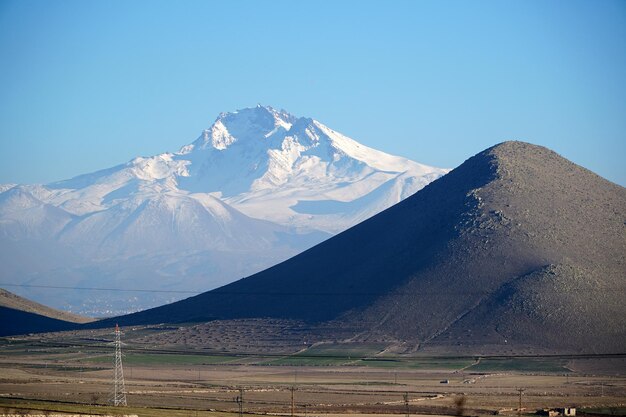 Photo a mountain with snow on it and a blue sky with a few clouds