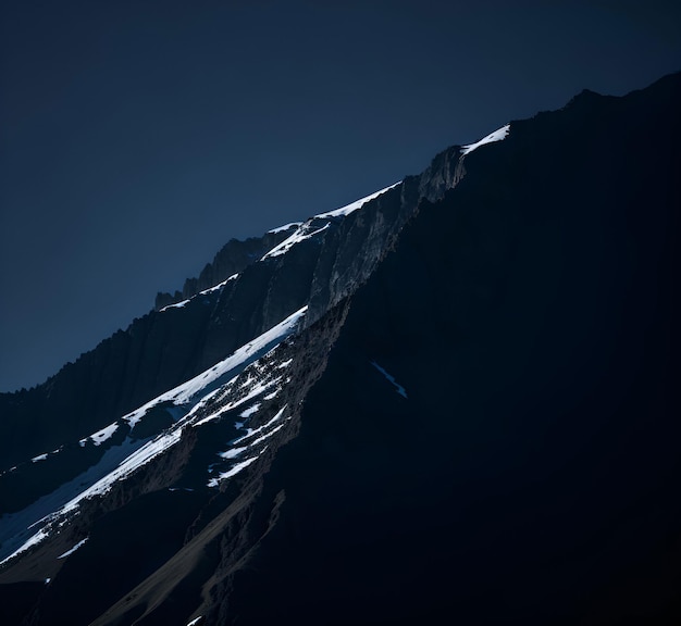 A mountain with snow on it and the sun shining on it.