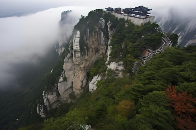 寺院があり、頂上が雲に覆われている山。