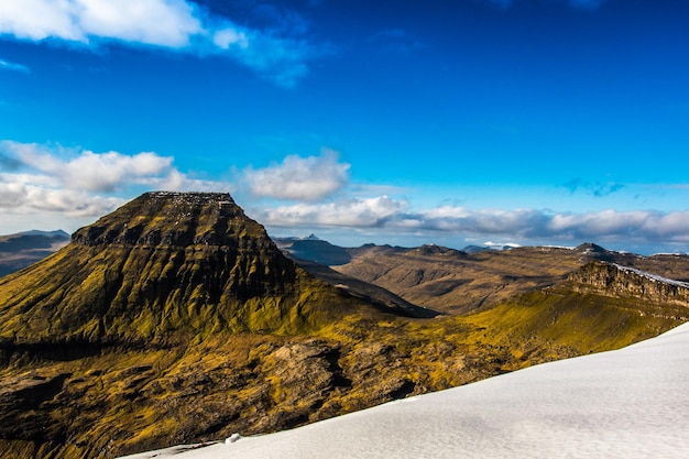 A mountain with a yellow and green landscape