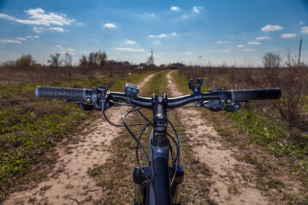 Mountainbiken bergafwaarts snel afdalend op de fiets. Uitzicht vanuit de ogen van motorrijders.