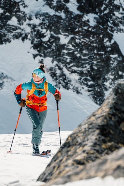 Foto alpinista sci d'alpinismo a piedi sci alpinista in montagna sci alpinismo nel paesaggio alpino con alberi innevati avventura sport invernale