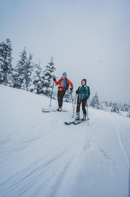 Альпинист прогулка на лыжах по пересеченной местности лыжный альпинист в горах Лыжный туризм в альпийском пейзаже со снежными деревьями Приключенческий зимний спорт