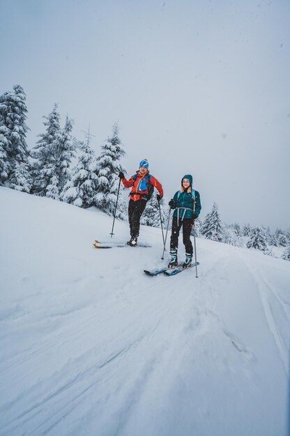 Mountaineer backcountry ski walking ski alpinist in the mountains Ski touring in alpine landscape with snowy trees Adventure winter sport