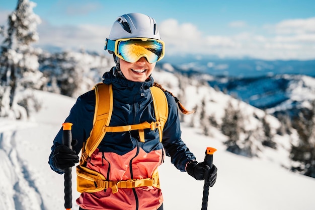 Mountaineer backcountry ski walking ski woman alpinist in the mountains Ski touring in alpine landscape with snowy trees Adventure winter sport Freeride skiing