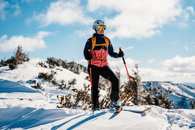 登山家 バックカントリー スキー ウォーキング スキー 山の中の女性アルピニスト 雪に覆われた木々 と高山の風景でのスキー ツーリング アドベンチャー ウィンター スポーツ フリーライド スキー