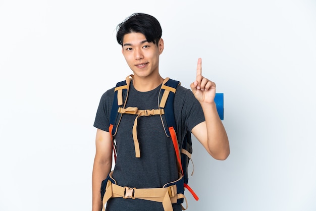 Mountaineer Chinese man with isolated on white wall showing and lifting a finger in sign of the best