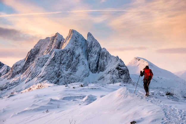 Человек альпинист поднимается на вершину снежной горы