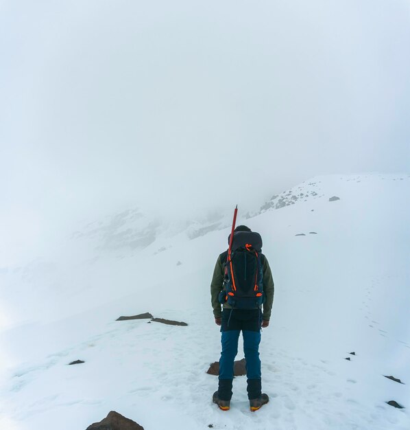 Foto un alpinista raggiunge la cima di una montagna