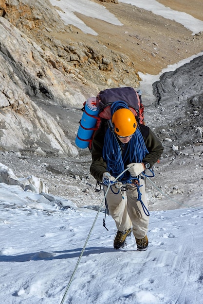 Alpinista raggiunge la cima di una montagna innevata, fann, pamir alay, tagikistan.