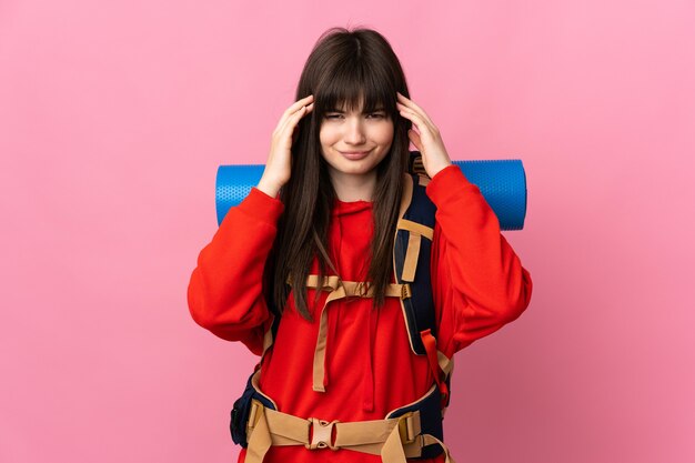 Mountaineer Ukrainian girl with a big backpack isolated on pink wall unhappy and frustrated with something. Negative facial expression