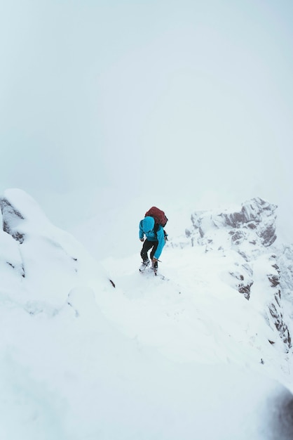 スコットランドのグレンシールにあるフォーカンリッジを登るためにピッケルを使用する登山家