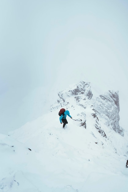 スコットランドのグレンシールにあるフォーカンリッジを登るためにピッケルを使用する登山家