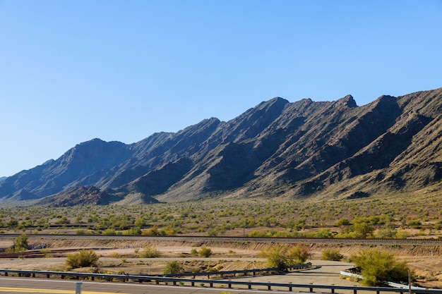 Mountains along desert and blue sky