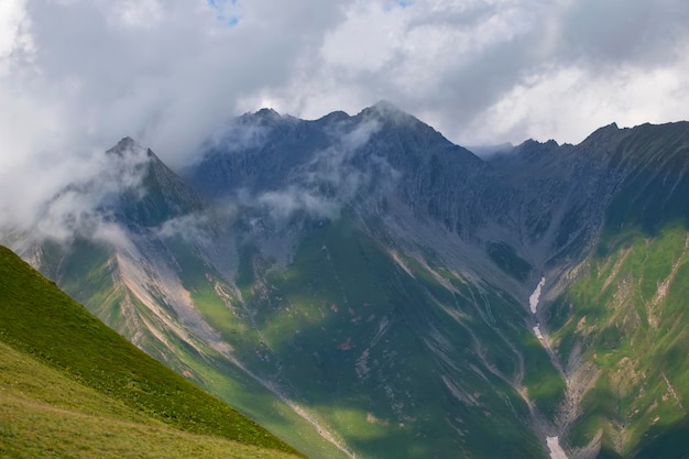 Mountains in clouds and clouds Aerial view of a mountain peak with green trees in the fog