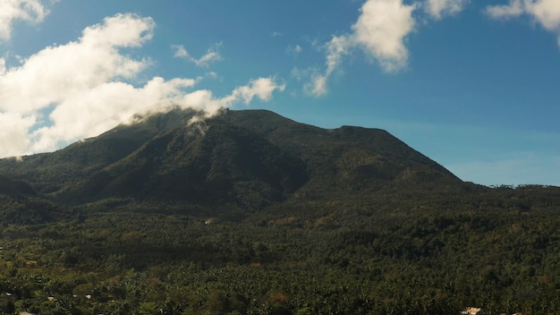 Mountains covered rainforest trees and blue sky with clouds aerial view camiguin philippines