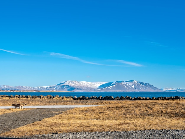 アイスランドの半島と灯台の近くのアクラネースの町の山のフィールドと海の景色