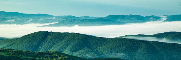 Mountains in the fog morning fog covered mountains and forests\
on a summer day